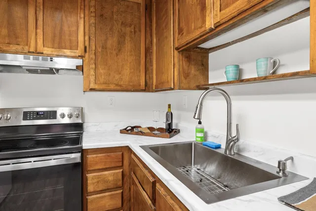 a kitchen with stainless steel appliances granite countertop a sink stove and cabinets