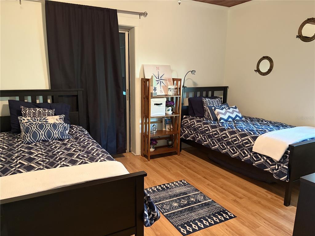 421 Riviera Street Venice, FL 34285 - Photo 13 of 30 a bedroom with a bed and a table with potted plant