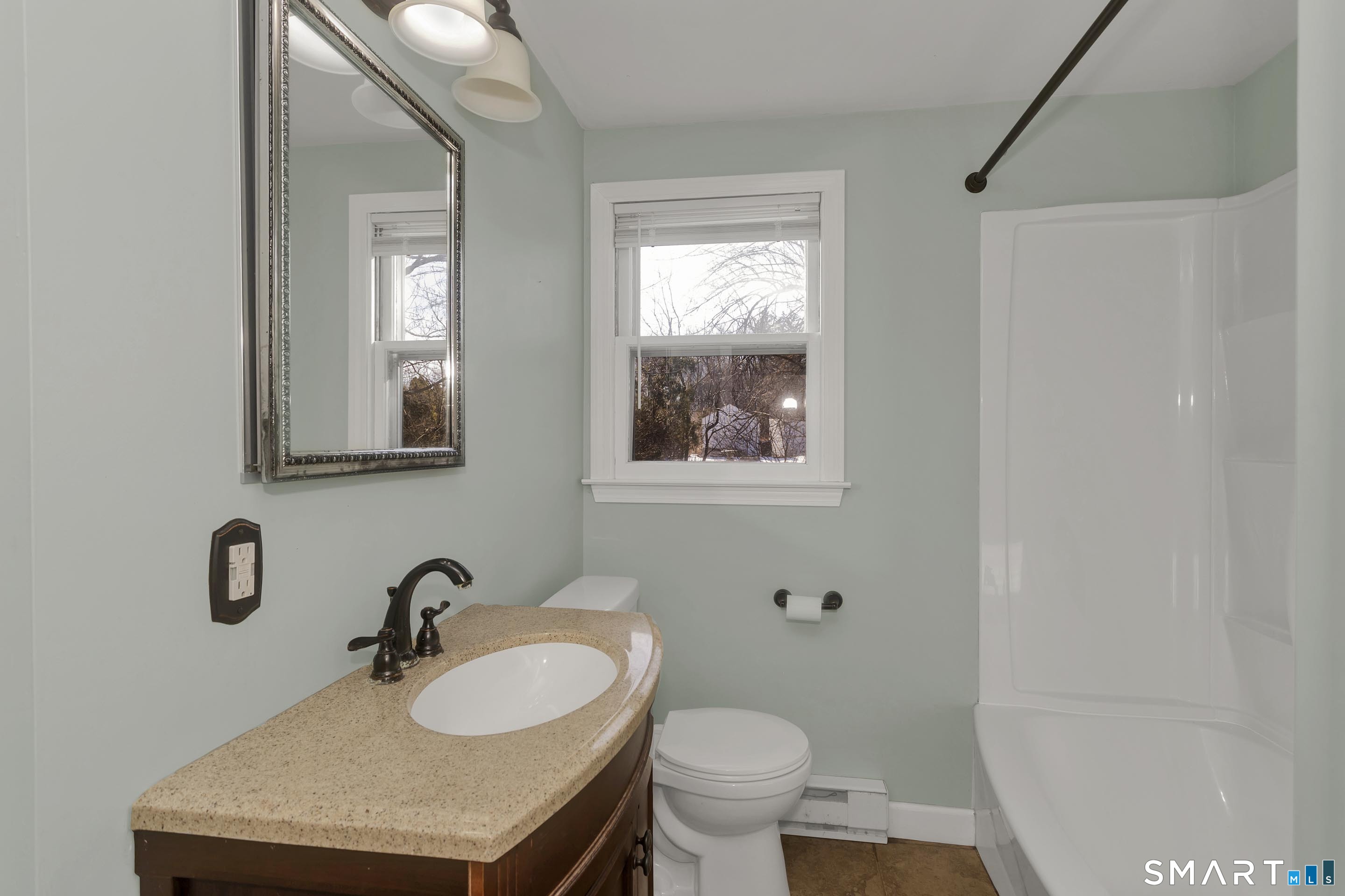 73 Laurel Street Enfield, CT 06082 - Photo 26 of 40 a bathroom with a toilet sink mirror and vanity
