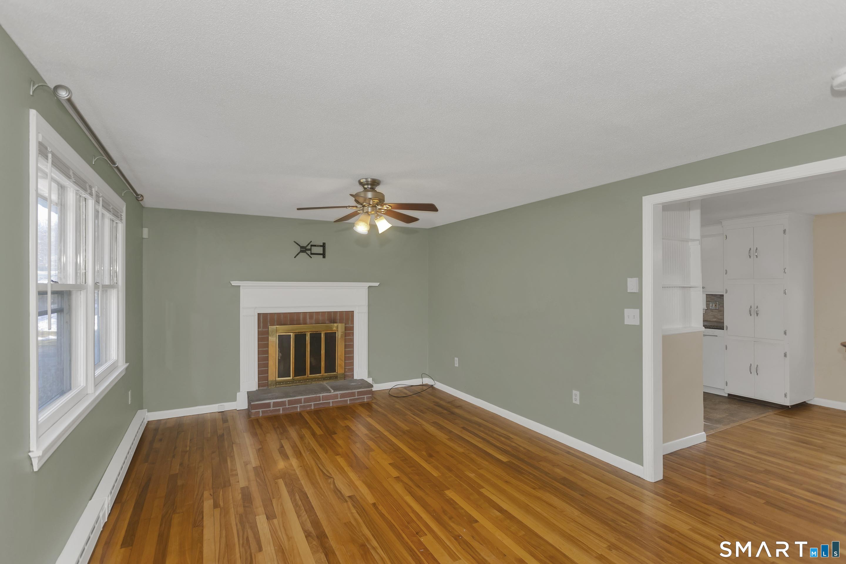 73 Laurel Street Enfield, CT 06082 - Photo 3 of 40 a view of empty room with wooden floor and fan