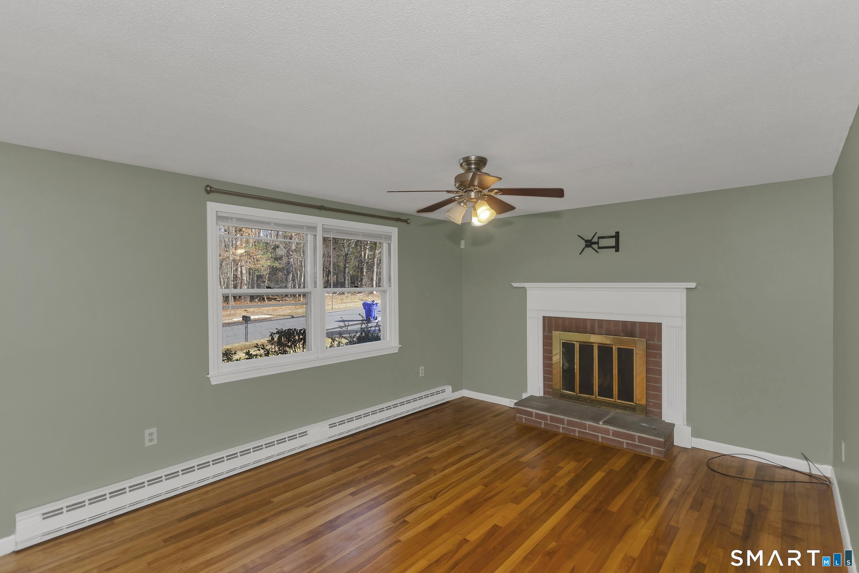 73 Laurel Street Enfield, CT 06082 - Photo 6 of 40 a view of empty room with wooden floor and fan