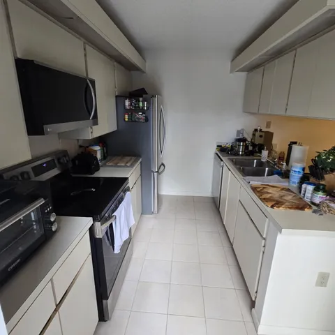 a kitchen with a sink stove top oven and cabinets