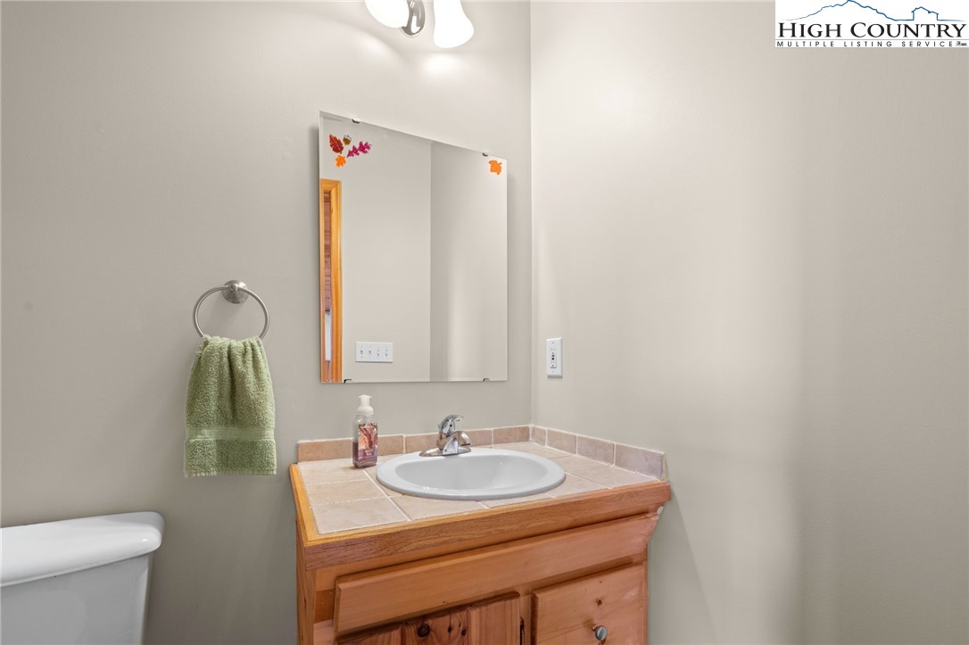 460 Deer Crossing Road Piney Creek, NC 28663 - Photo 16 of 29 a bathroom with a sink and a mirror
