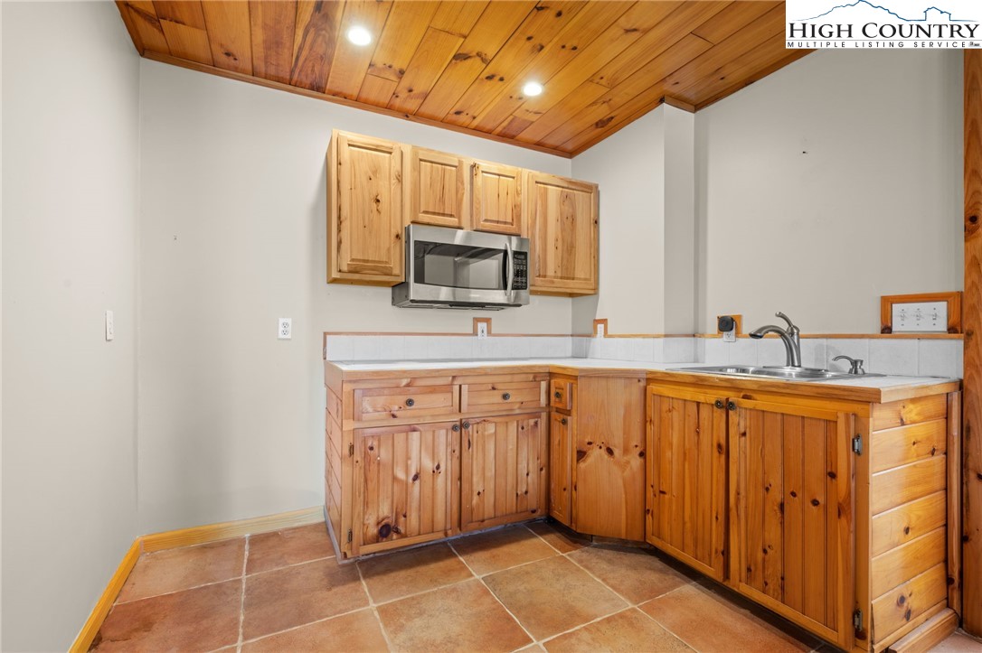 460 Deer Crossing Road Piney Creek, NC 28663 - Photo 21 of 29 a large kitchen with stainless steel appliances granite countertop a sink and cabinets