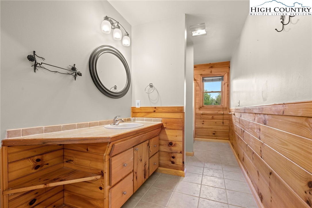460 Deer Crossing Road Piney Creek, NC 28663 - Photo 25 of 29 a bathroom with a granite countertop sink a mirror and shower