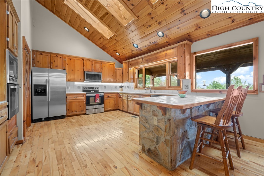 460 Deer Crossing Road Piney Creek, NC 28663 - Photo 4 of 29 a kitchen with stainless steel appliances granite countertop a sink a stove and a refrigerator