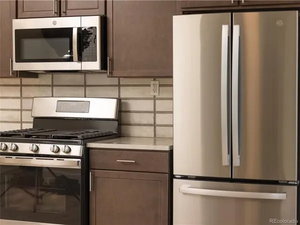 a kitchen with stainless steel appliances granite countertop a refrigerator and a microwave