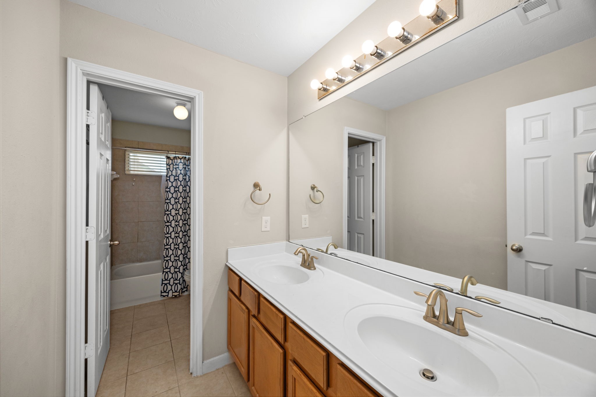 6719 Latchmore Lane Houston, TX 77049 - Photo 33 of 46 a bathroom with a double vanity sink and a mirror