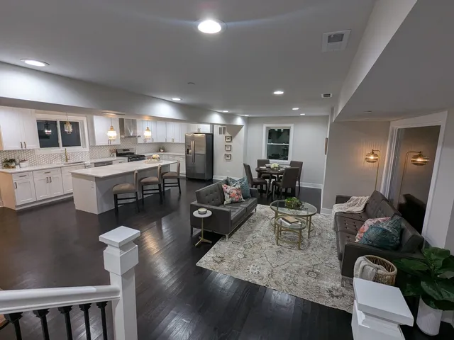 a view of a dining room with furniture a rug and wooden floor