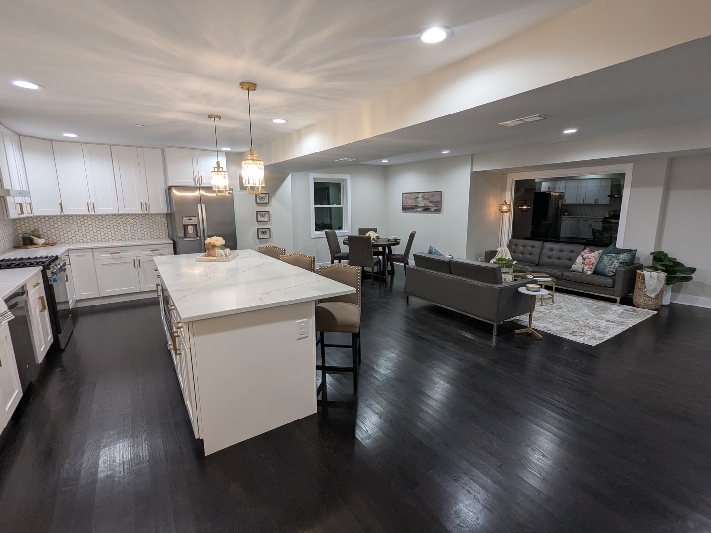 8600 East Prairie Road Skokie, IL 60076 - Photo 16 of 37 a living room with couches and kitchen view with wooden floor