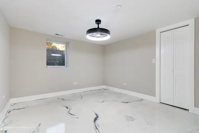 an empty room with a ceiling fan and entryway