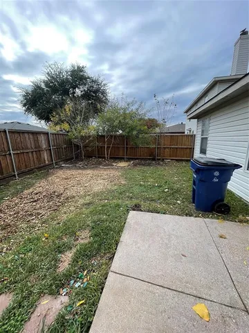 a view of a backyard with potted plants and wooden fence
