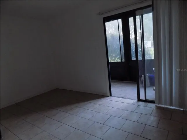 an empty room with closet and a chandelier fan