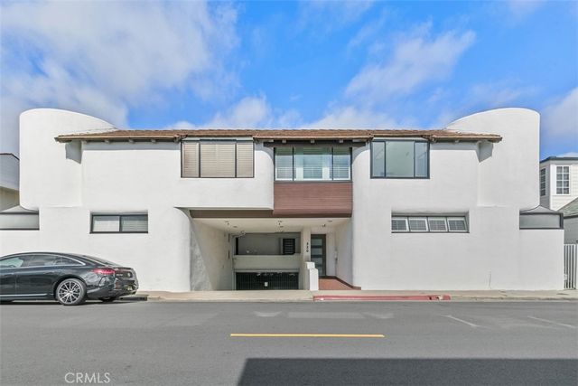 a view of an empty room with wooden floor and a fireplace