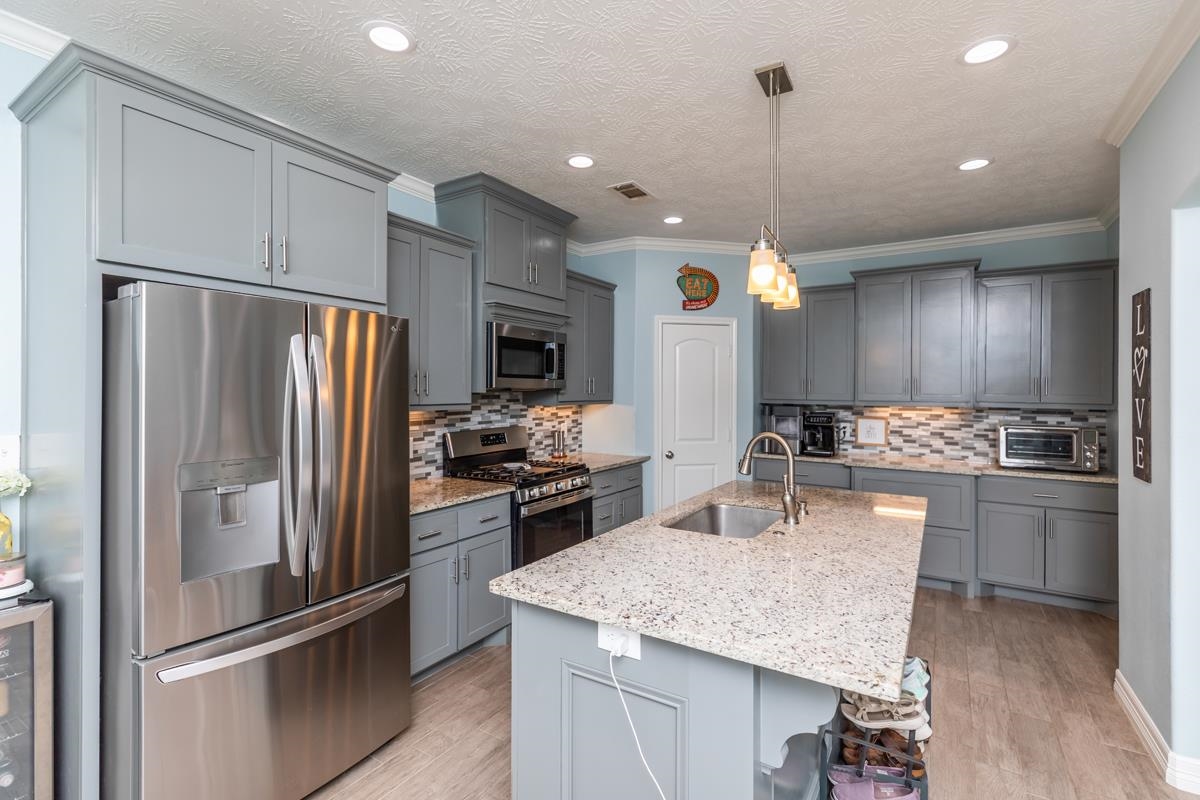 314 Long Leaf Street Silsbee, TX 77656 - Photo 9 of 31 a kitchen with refrigerator a sink and chairs