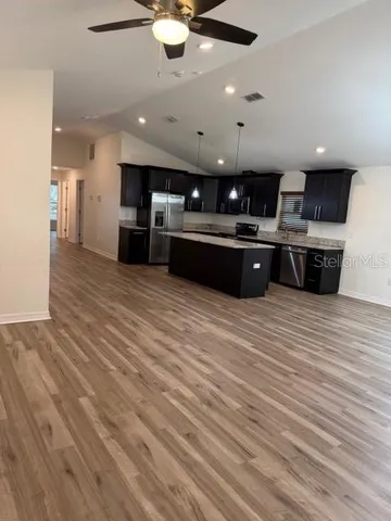 a large kitchen with stainless steel appliances granite countertop a stove and a sink