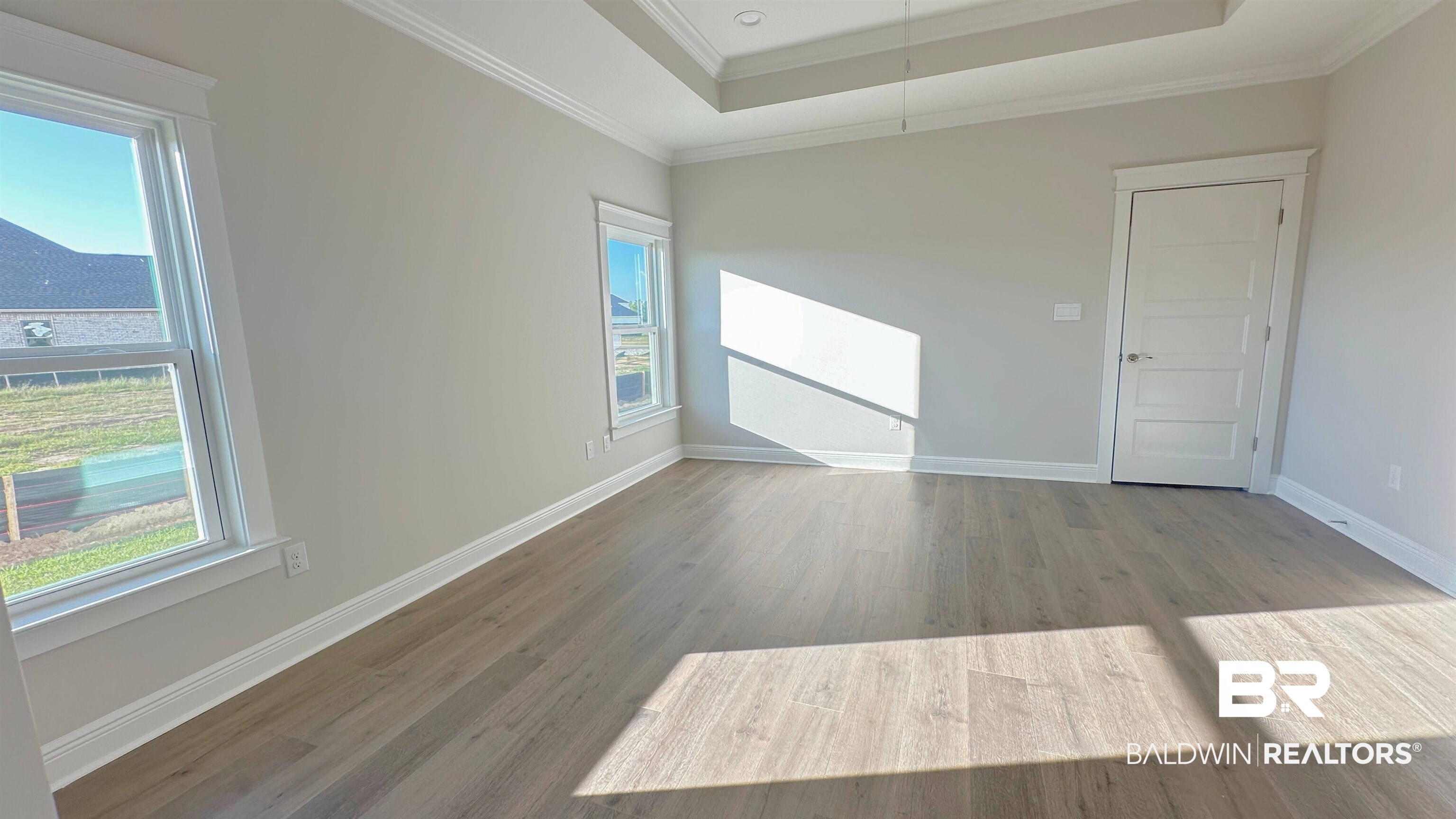 126 Daybreak Trail Fairhope, AL 36532 - Photo 12 of 34 Unfurnished room with a tray ceiling, ornamental molding, and wood finished floors