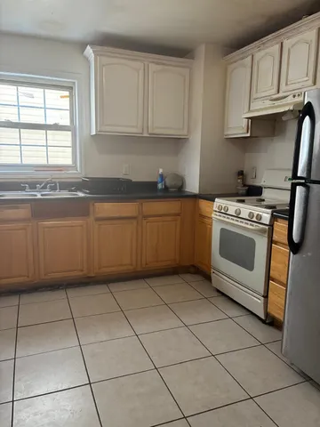 a kitchen with granite countertop white cabinets and appliances