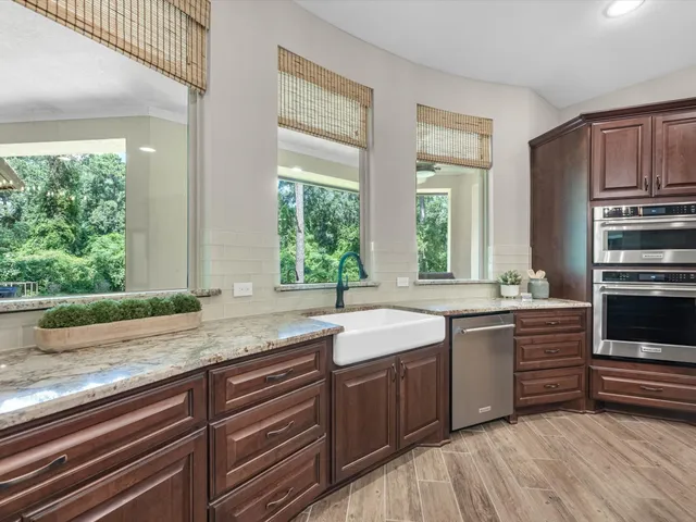 a kitchen with stainless steel appliances granite countertop a sink and wooden cabinets