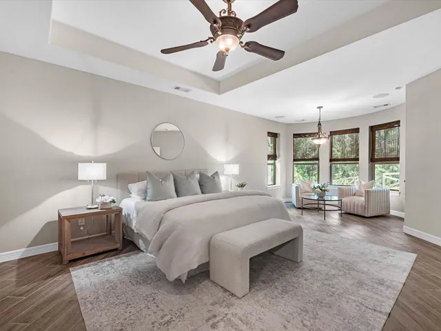 a spacious bedroom with a bed a chandelier and large window