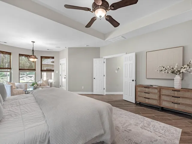 a spacious bedroom with a bed and ceiling fan