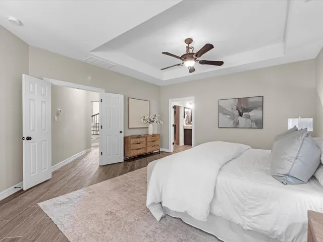 a spacious bedroom with a bed and a chandelier