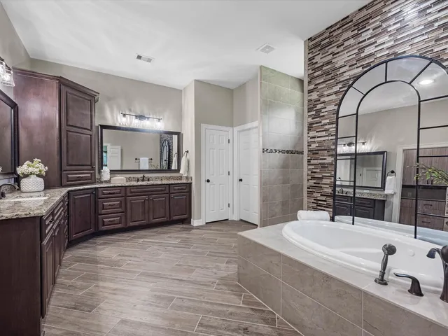 a bathroom with a tub sink and mirror