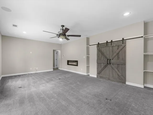 a view of a livingroom with a ceiling fan and hardwood floor