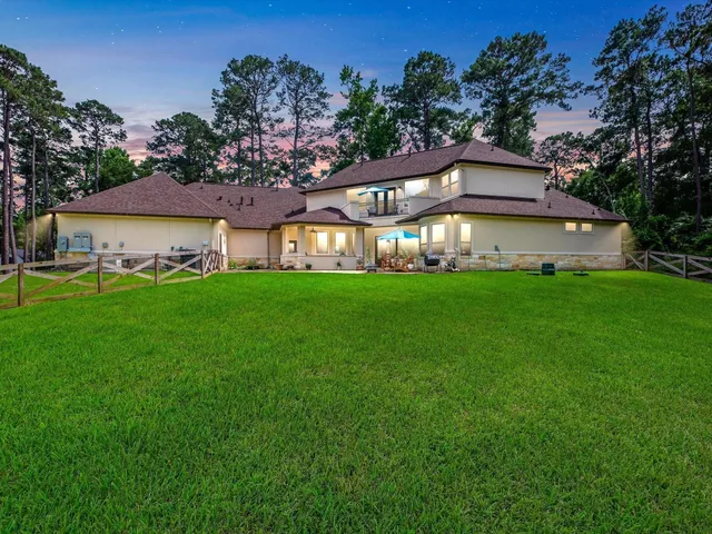 a view of a house with a big yard and large trees