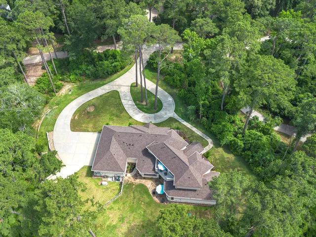 an aerial view of a house with outdoor space and swimming pool