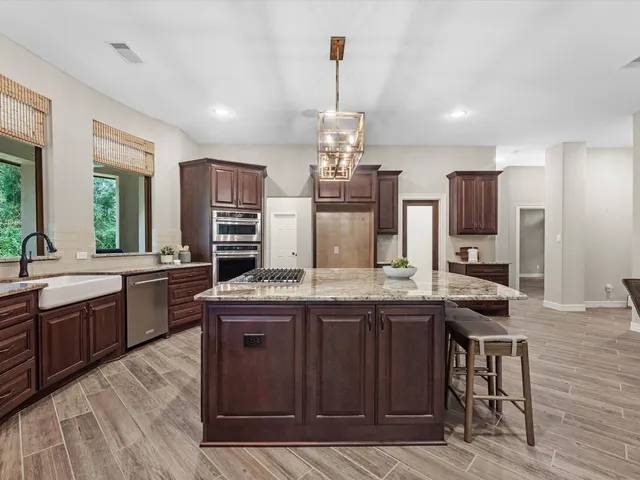 a kitchen with kitchen island granite countertop a sink stove and refrigerator