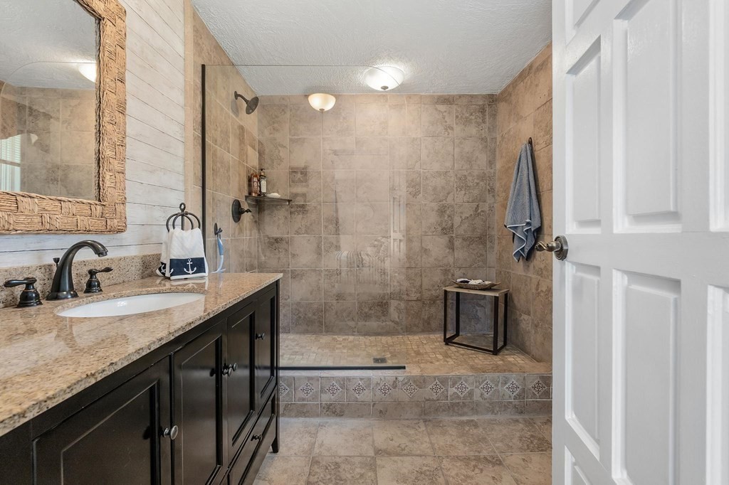 18 Durham Drive Lynnfield, MA 01940 - Photo 14 of 35 a bathroom with a granite countertop sink a mirror and shower