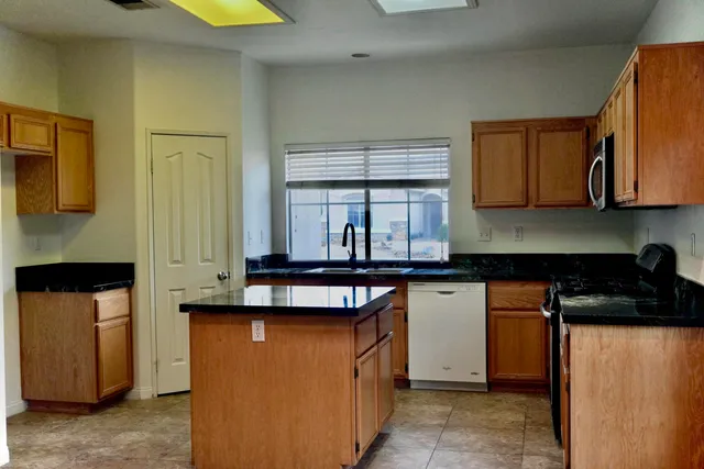 a kitchen with stainless steel appliances granite countertop a stove a sink and a refrigerator