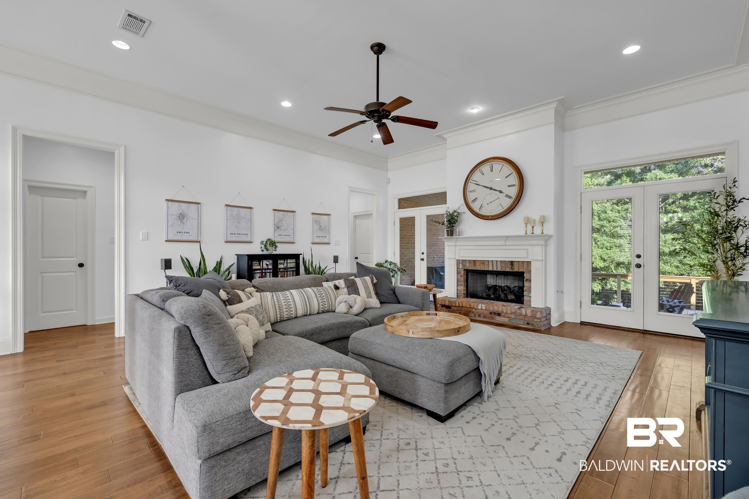 8137 Pine Run Daphne, AL 36527 - Photo 15 of 67 Spacious living area featuring wood-finish flooring, a brick fireplace with a white mantel, and double glass-paned doors