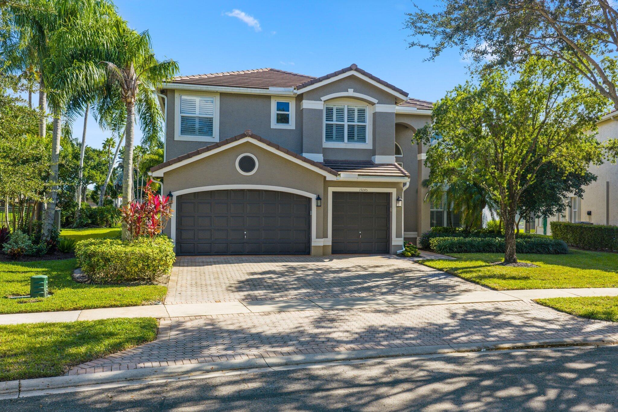 19245 Skyridge Circle Boca Raton, FL 33498 - Photo 59 of 70 a front view of a house with a yard and garage