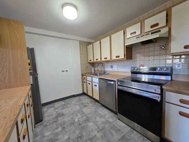 a kitchen with stainless steel appliances granite countertop a stove a sink and a refrigerator