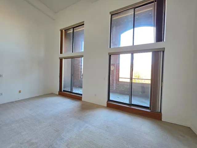 an empty room with windows and closet