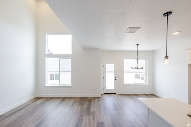 4812 Heartwood Road, Unit 424 Mapleton, UT 84664 - Photo 11 of 20 Unfurnished living room with suspended lighting, dark wood finished floors, and a textured ceiling