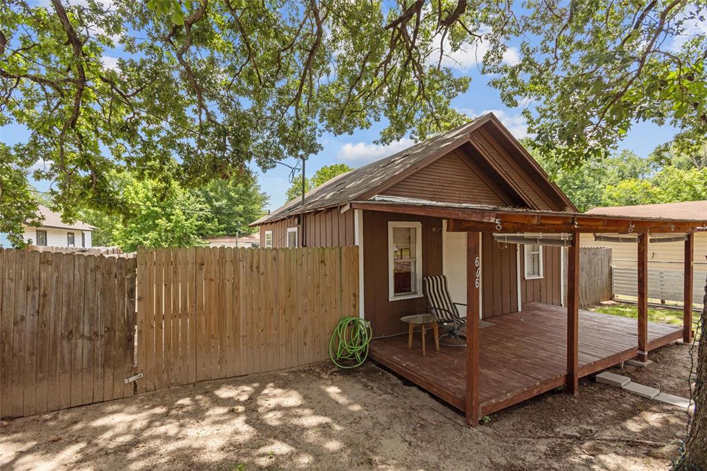 a view of a small house with wooden fence