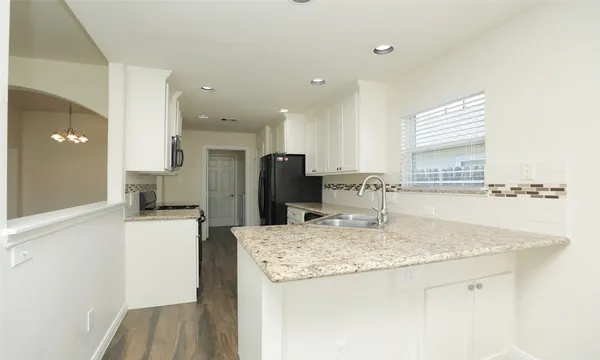a kitchen with stainless steel appliances granite countertop a sink refrigerator and cabinets