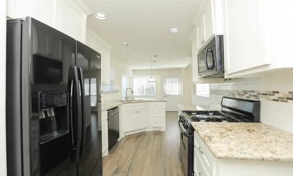 a kitchen with a refrigerator and a stove top oven
