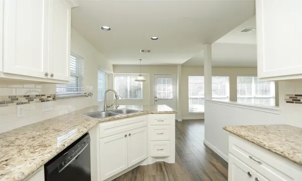 a kitchen with granite countertop kitchen island a sink appliances cabinets and a counter top space