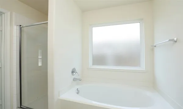 a white bath tub sitting next to a shower