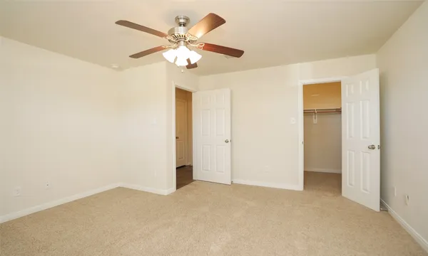 a view of an empty room with a chandelier fan