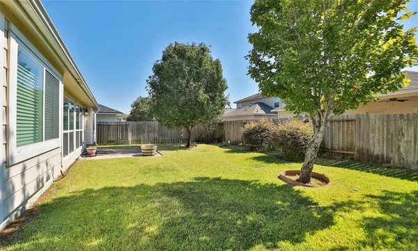 a swimming pool with yard and wooden fence