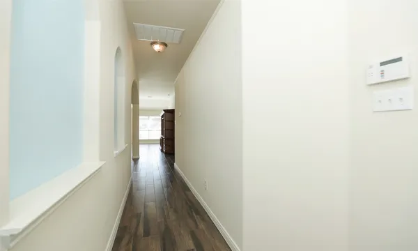 a view of a hallway with wooden floor