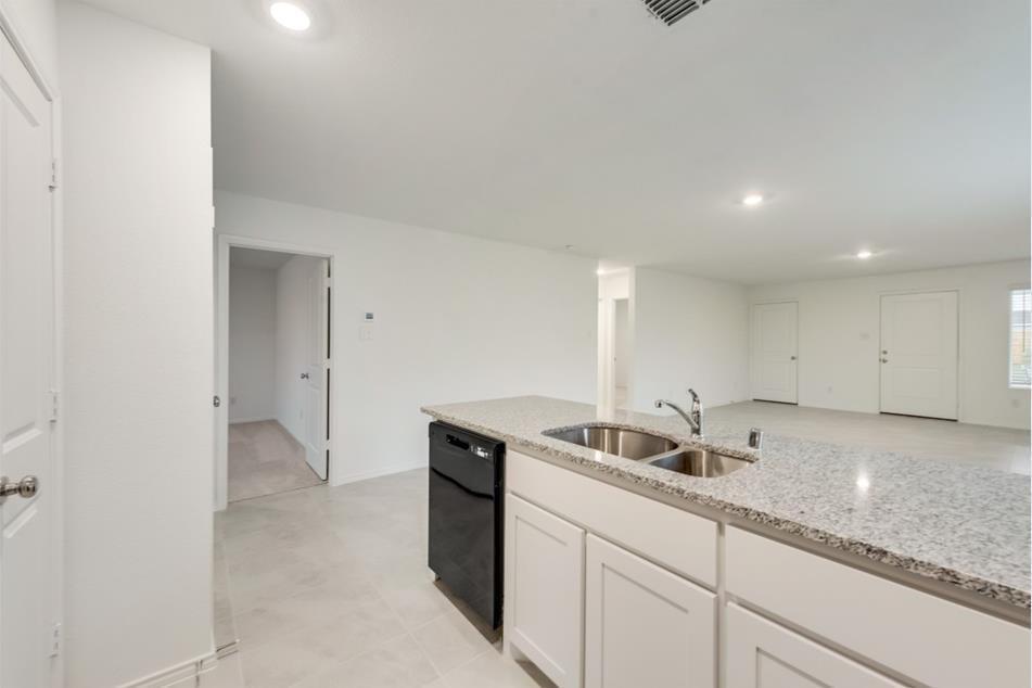 9832 Trusler Road Fort Worth, TX 76179 - Photo 5 of 13 a kitchen with stainless steel appliances granite countertop a sink and a white cabinets