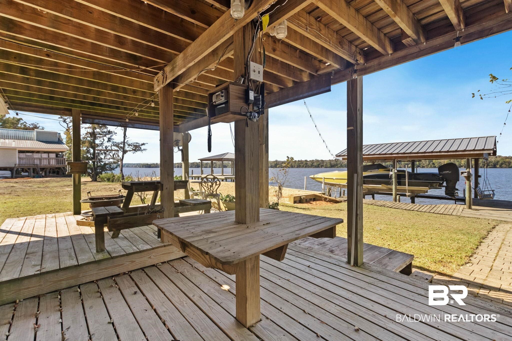 41997 Bayou Road Bay Minette, AL 36507 - Photo 55 of 68 Wooden deck featuring boat lift, a water view, and a boat dock