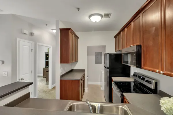 a kitchen with stainless steel appliances granite countertop a refrigerator and a stove top oven