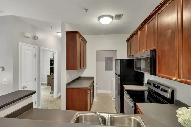 a kitchen with stainless steel appliances granite countertop a refrigerator and a stove top oven